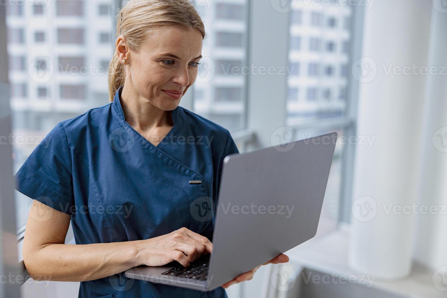 Female healthcare worker using laptop while working at doctor's office photo