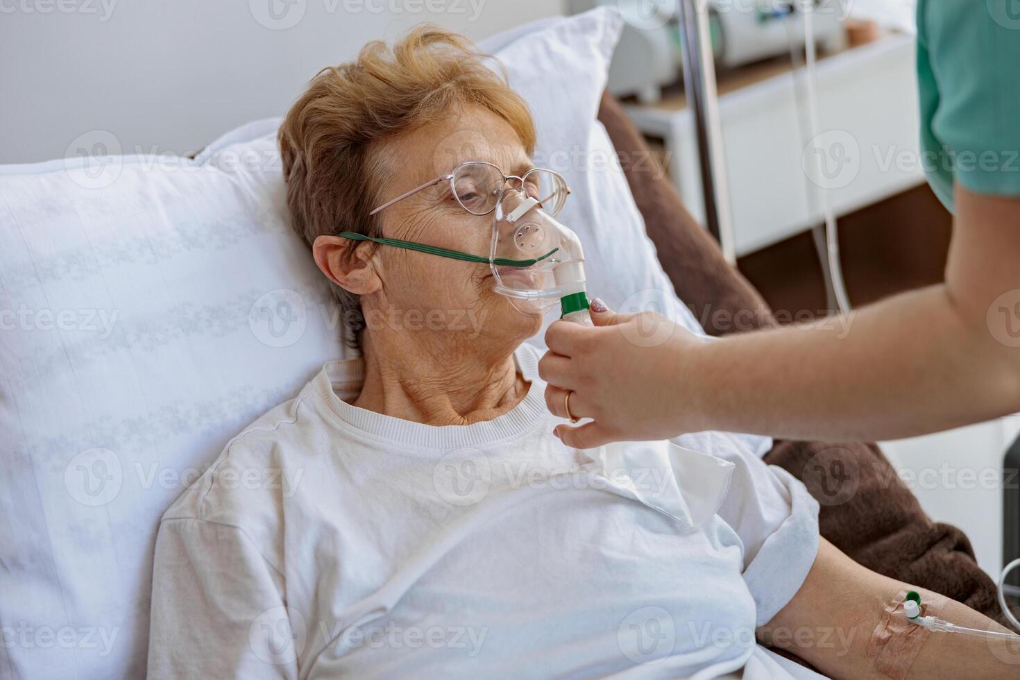 Nurse putting on a breathing mask on a female patient with covid-19 photo