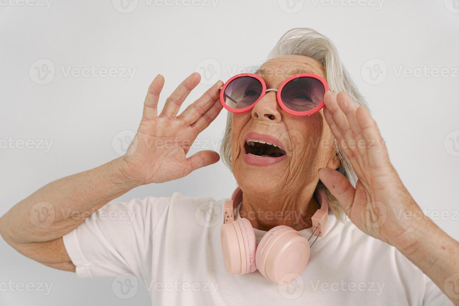 A Joyful Elderly Woman Wearing Sunglasses and Headphones Radiates Happiness and Energy photo
