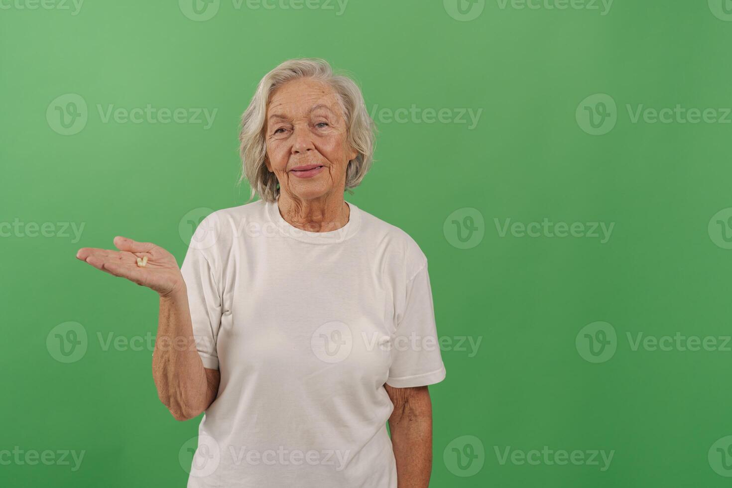 Elderly Woman Smiling and Gesturing Happily with a Cheerful Expression on a Green Screen photo