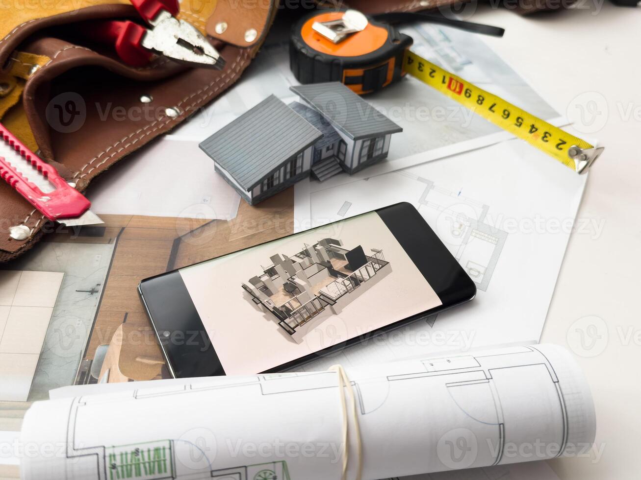 Architectural model on desk with smartphone, drawing technical tools and blueprints. Architecture, building, construction and real estate business. photo