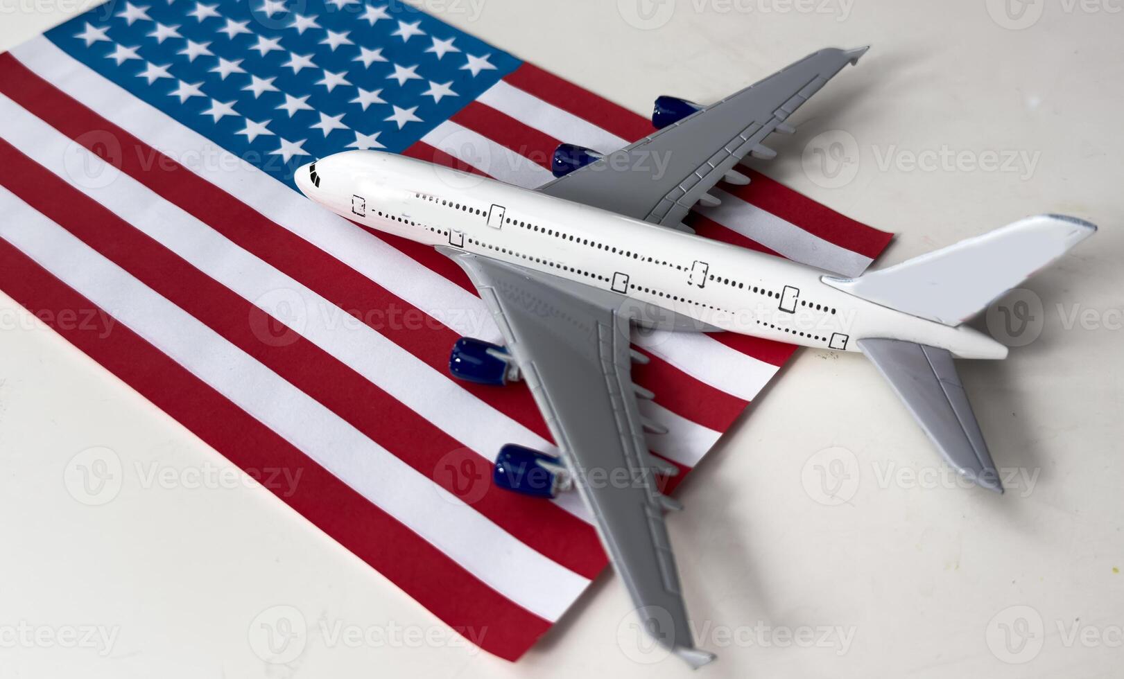 Toy plane with american flag on grey background. Top view photo