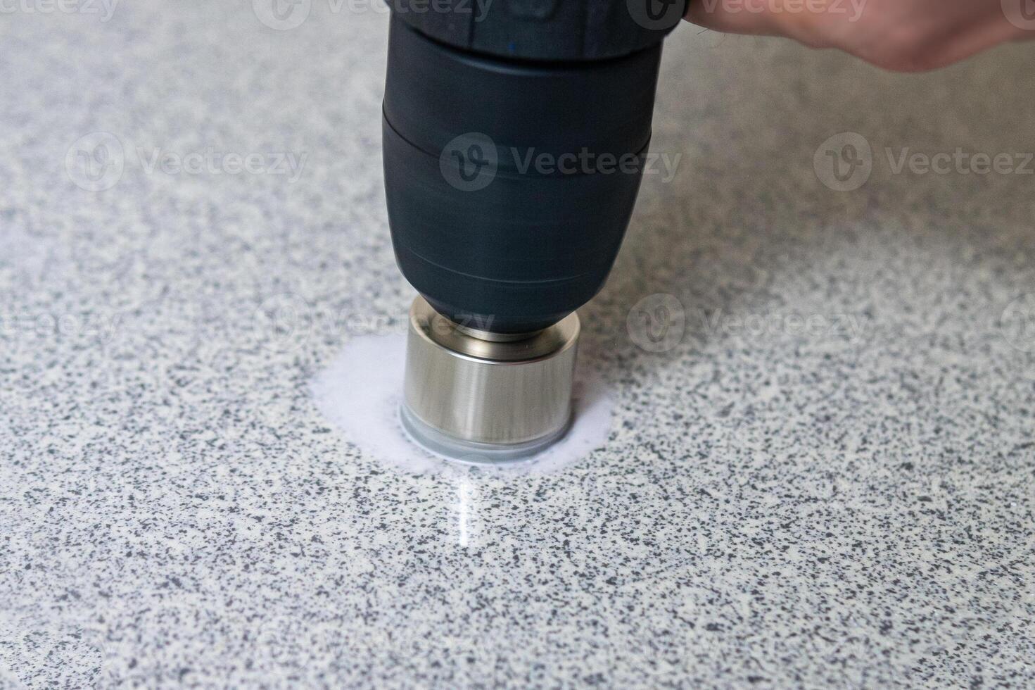 rotating diamond core hole cutter in hand power drill drills stone slab photo