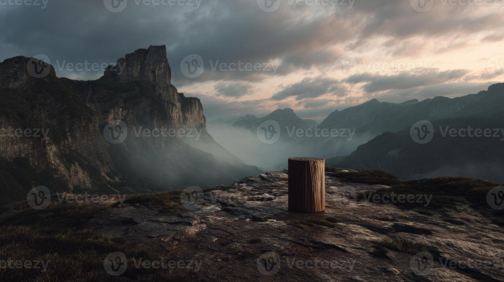 Misty mountain landscape with wood log on rocky cliff during sunset photo