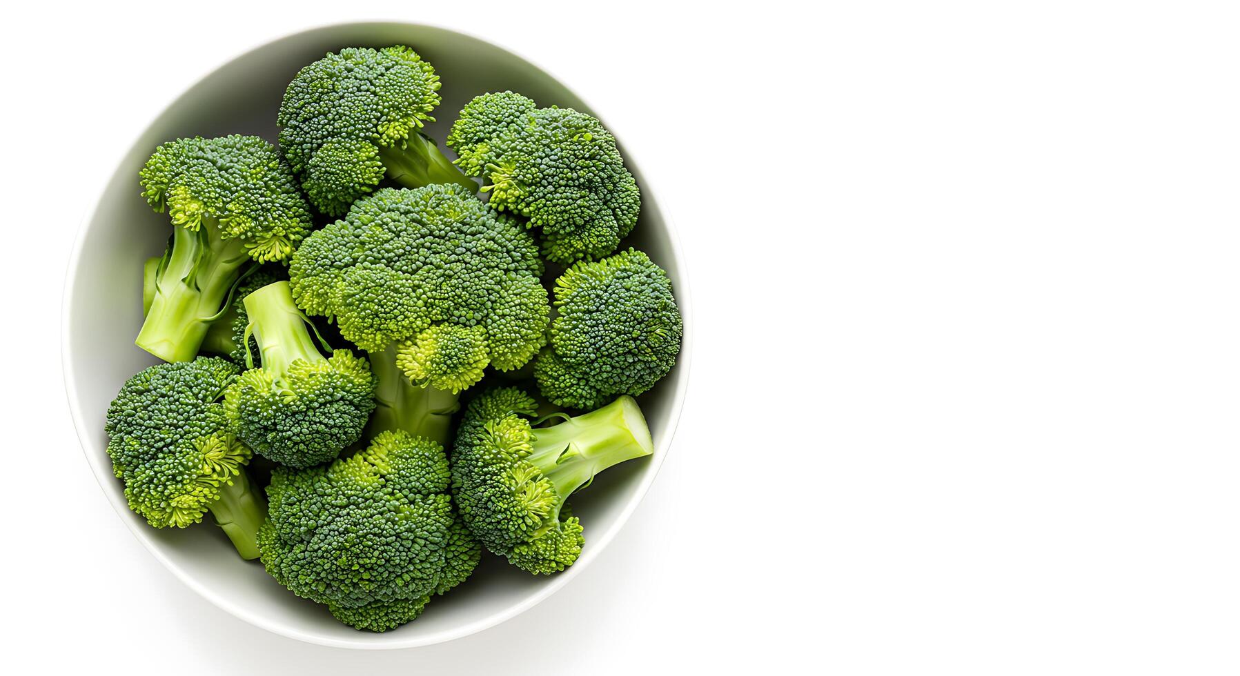 A bowl of broccoli is shown on a white surface photo