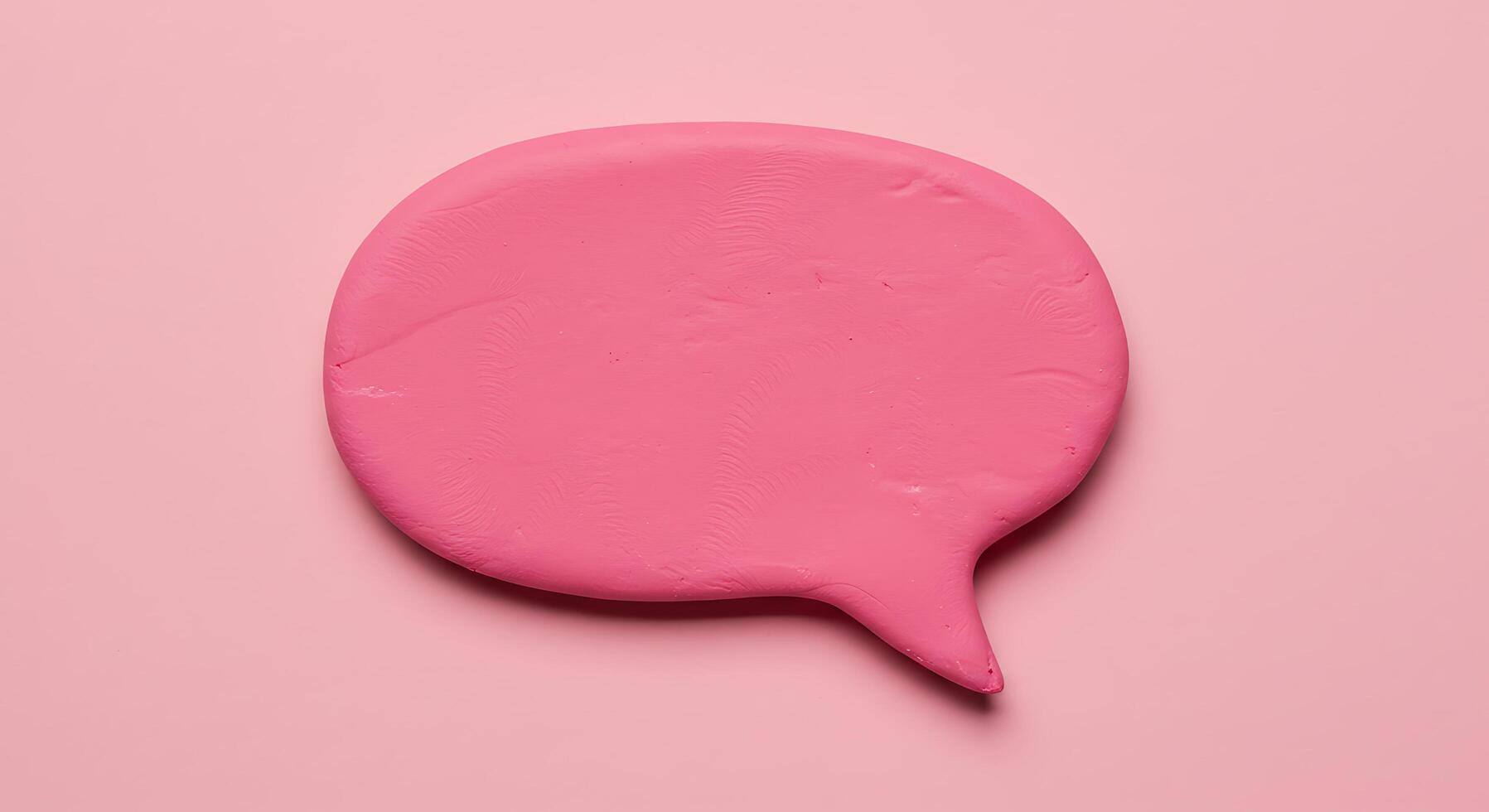 A pink speech bubble on a pink background photo