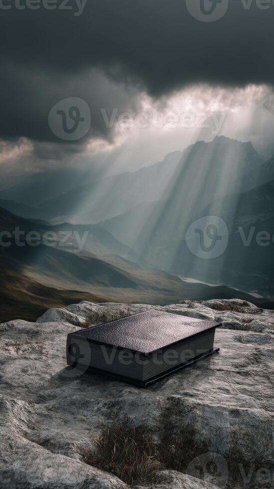 Mystical book on rocky mountain under dramatic sky with sun rays, fantasy concept photo