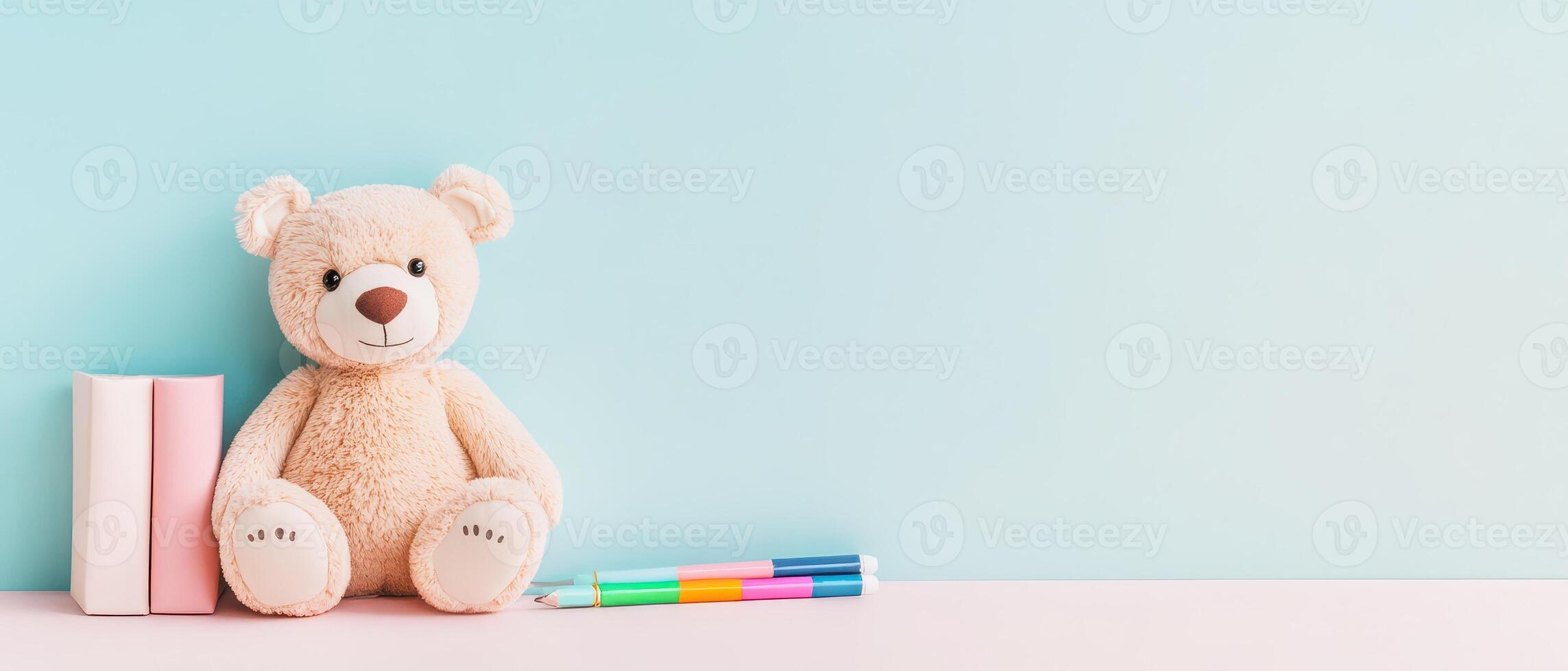 Soft teddy bear next to books and colorful markers photo