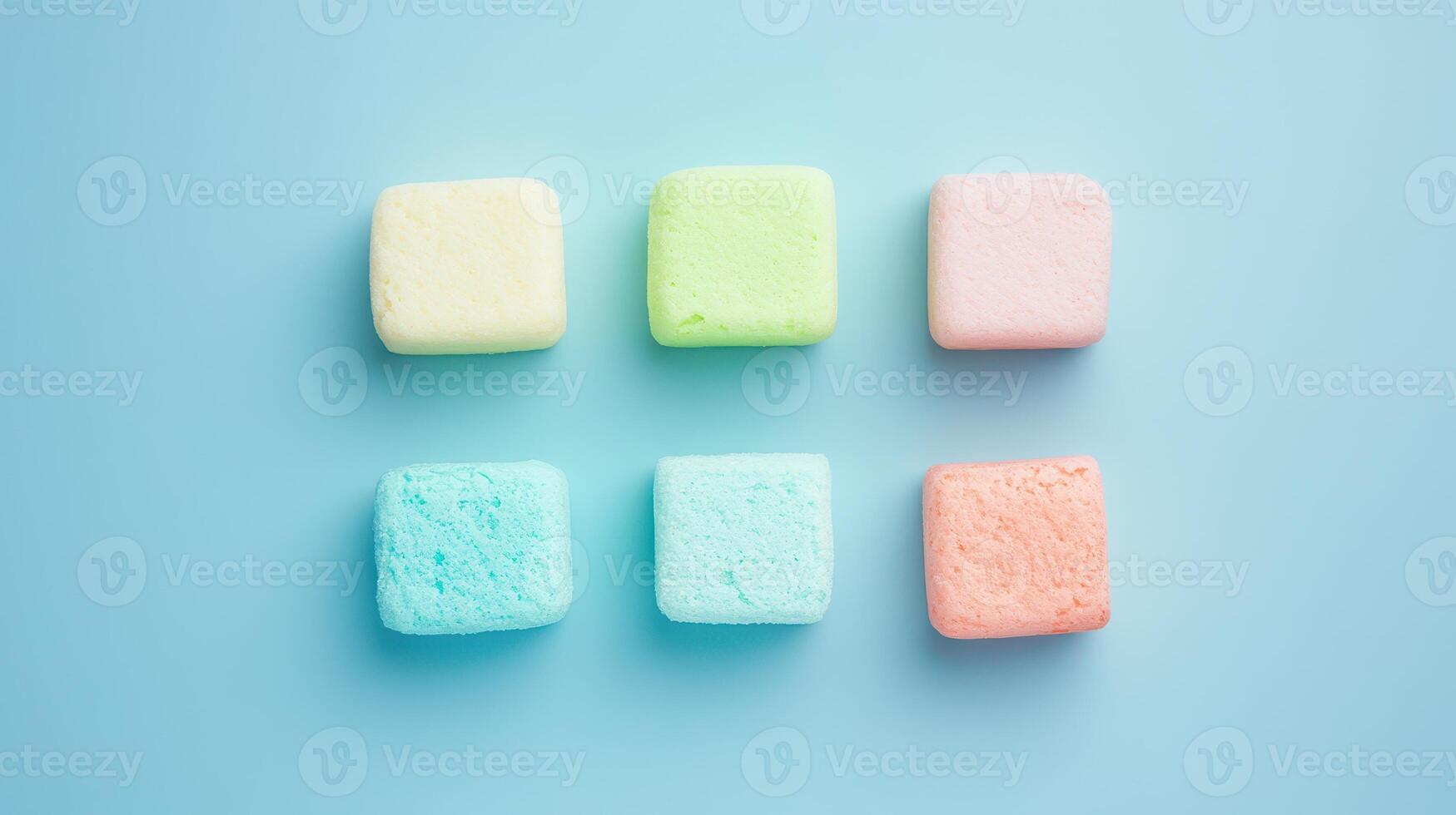 Colorful squares of foam displayed on blue surface photo