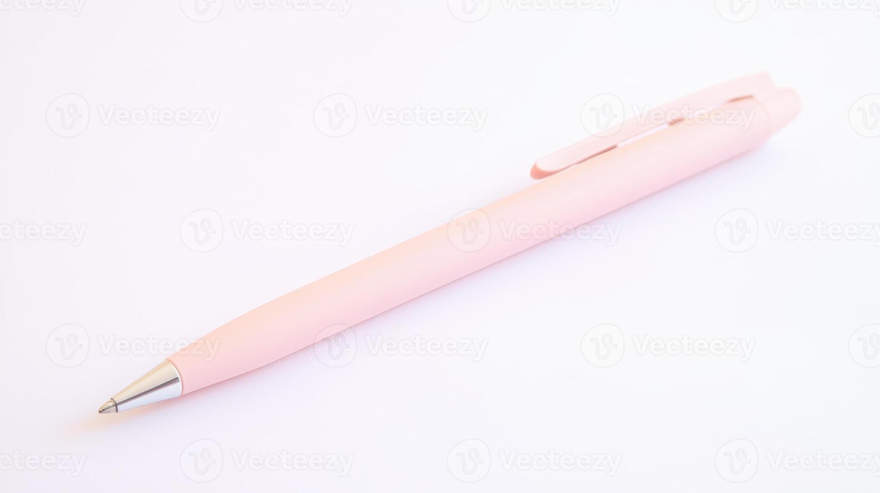 Pink pen resting on a clean white surface photo