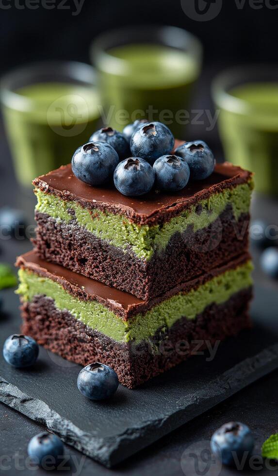 Delicious chocolate berry dessert layers. Layers of rich chocolate cake with vibrant green filling and fresh blueberries on top create a tempting dessert. photo