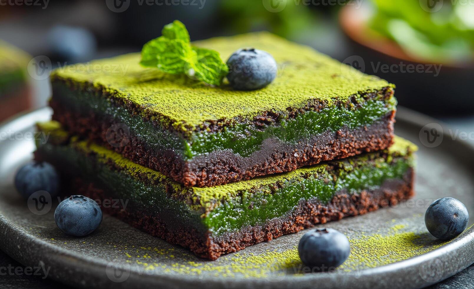 Yummy matcha blueberry treat. Layers of matcha and chocolate create a tempting dessert garnished with fresh blueberries and mint leaves. photo