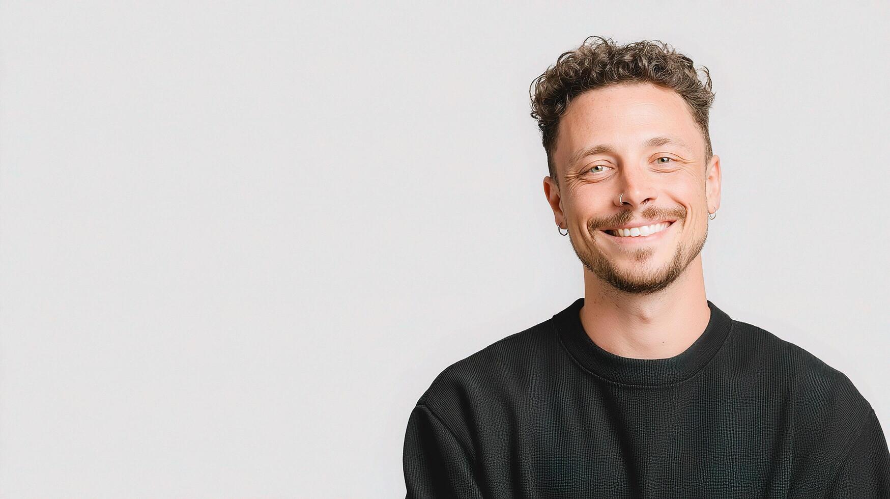 A man with curly hair and a black sweater photo