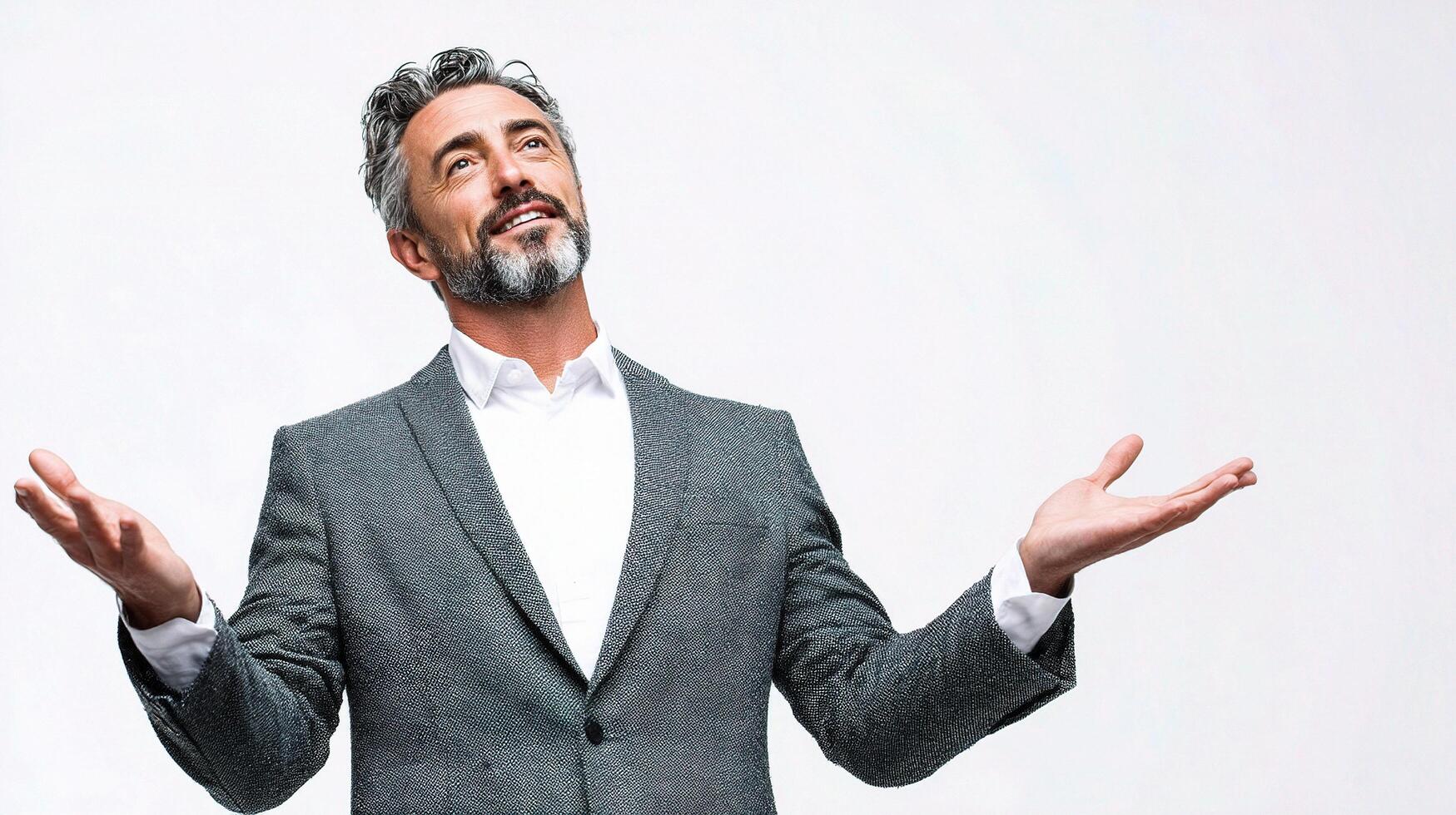 A man with a beard and suit is standing with his hands out photo