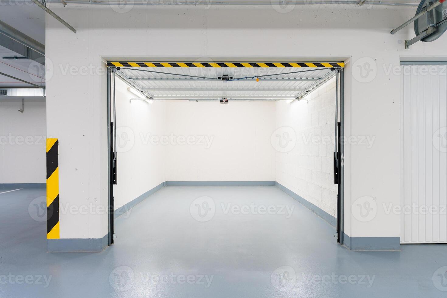Clean, modern underground garage in a Czech apartment building with remote-controlled metal doors. photo