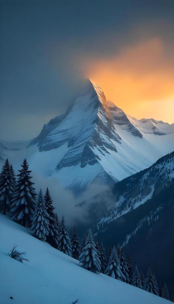 A mountain with snow covered trees and a sun setting behind it photo