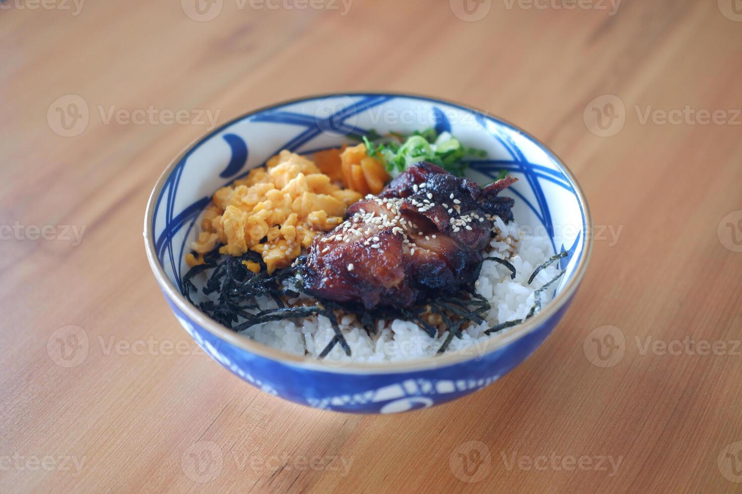 The bowl contains white steamed rice as the base, topped with various colorful ingredients photo