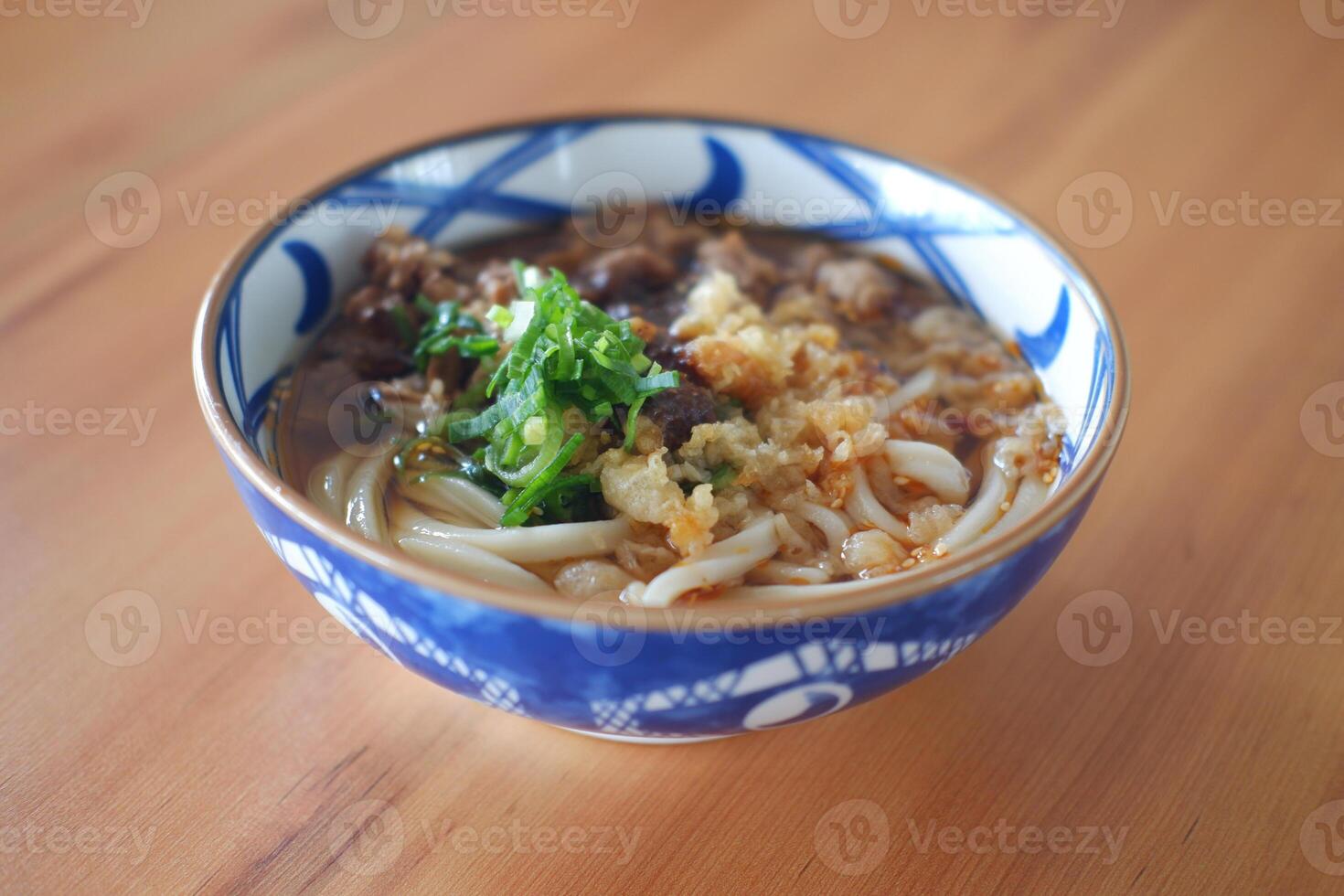 a bowl of Japanese-style noodle soup, likely udon, served in a beautifully patterned blue and white bowl photo