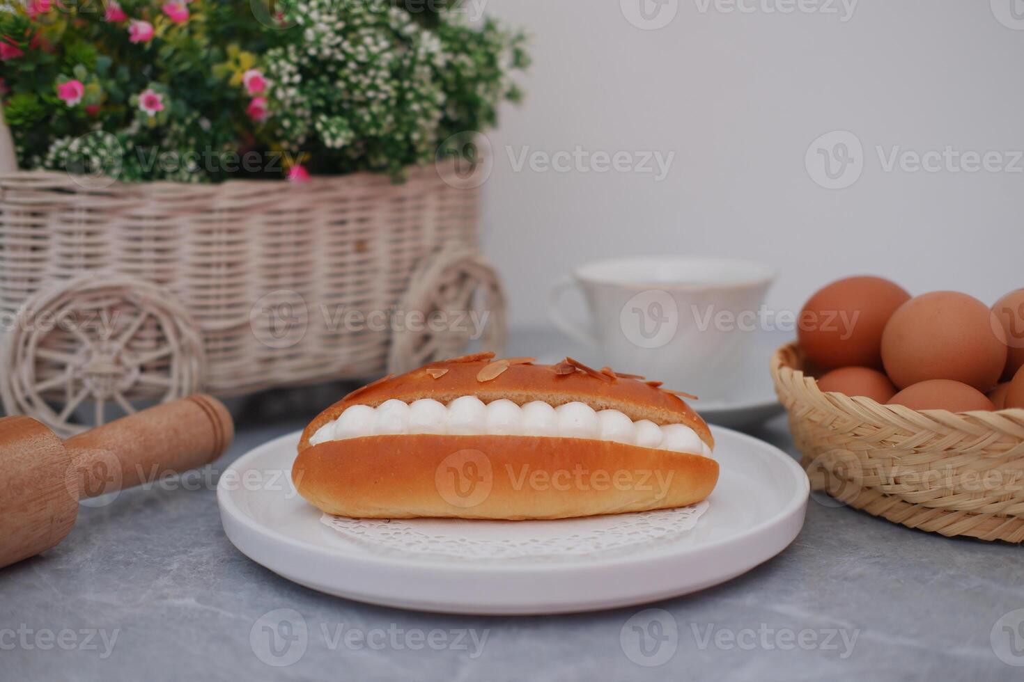 Cream-Filled Almond Pastry on a Plate with Eggs and Flowers photo
