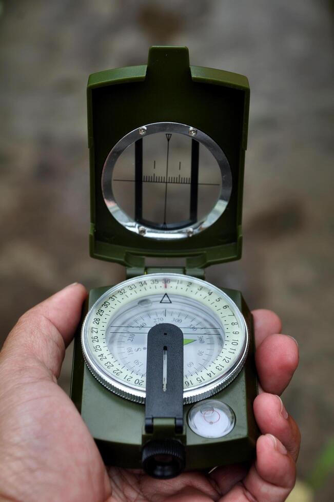 Holding outdoor adventure navigation compass selective focus photo