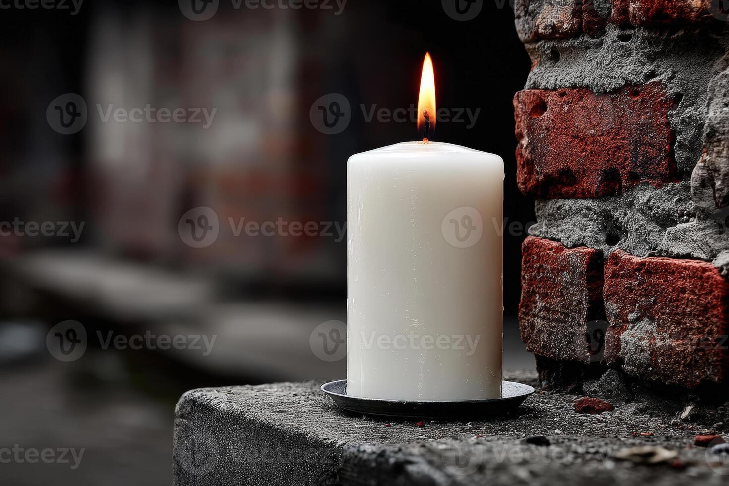 Candle placed against a weathered brick wall in a dimly lit area during evening hours photo