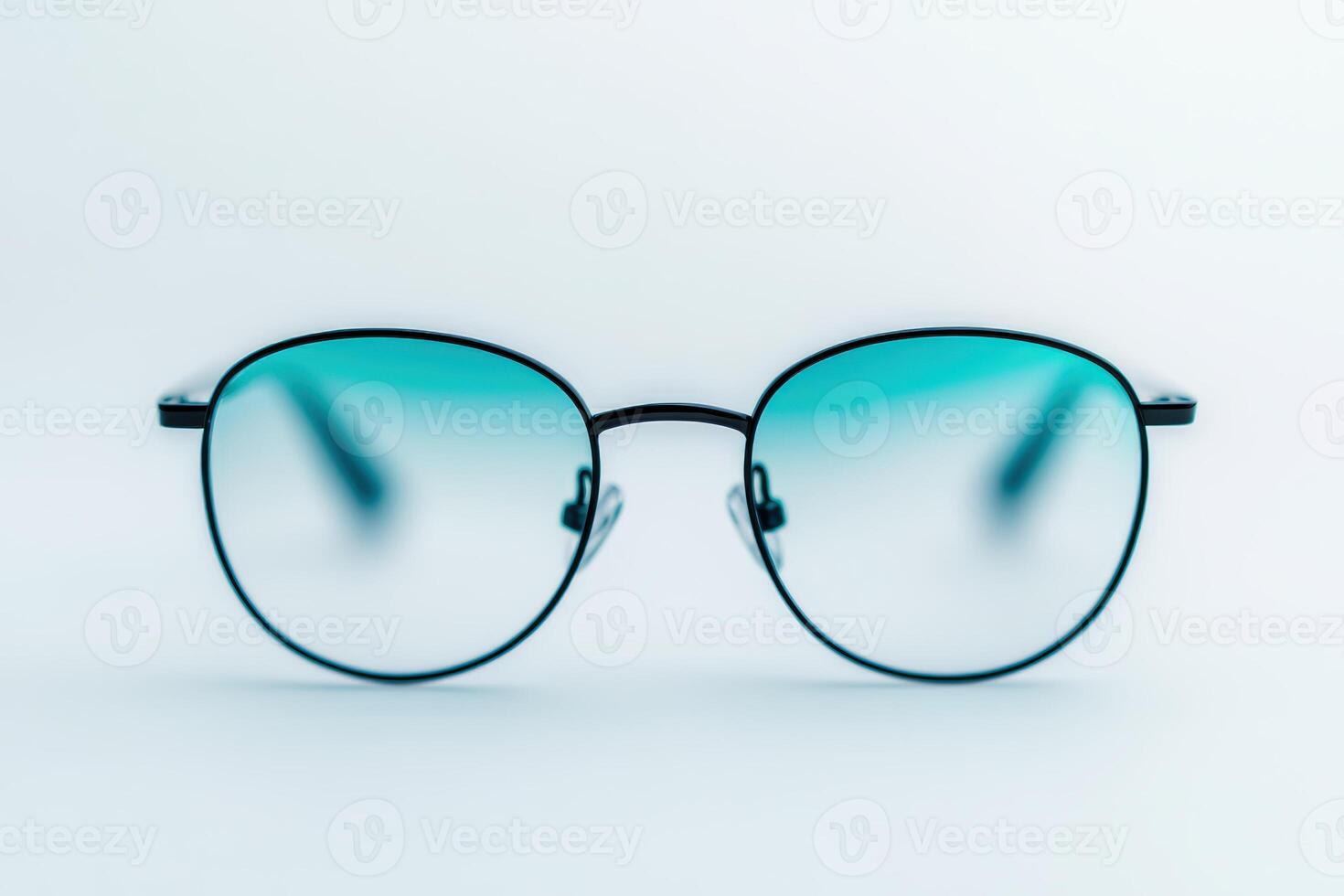 Stylish round glasses with teal-tinted lenses on a clean surface for modern eyewear appeal photo