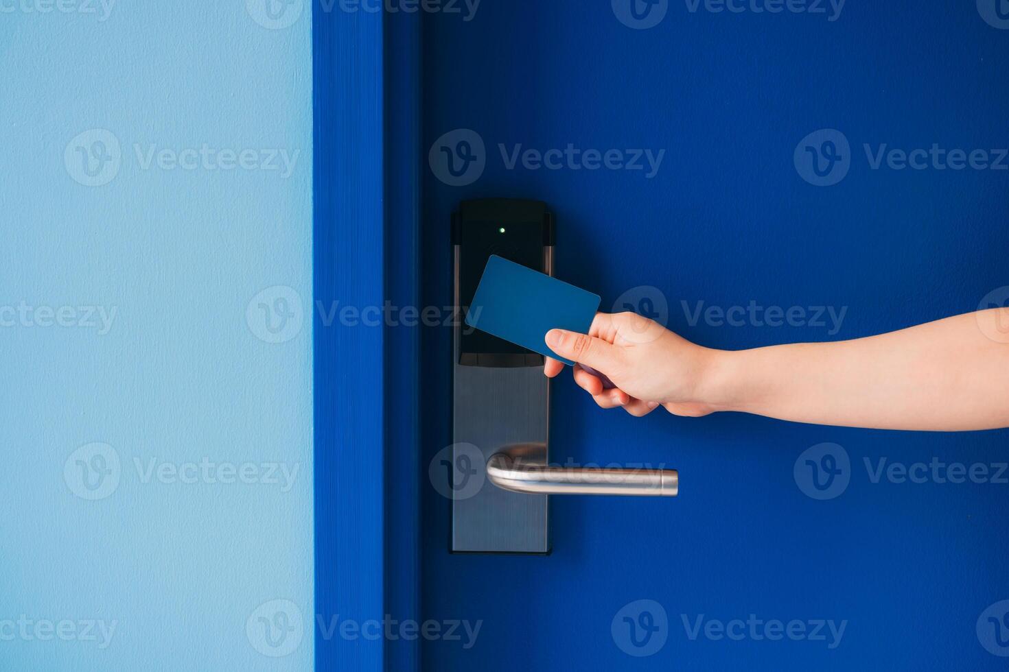 A person holding a credit card to a door photo
