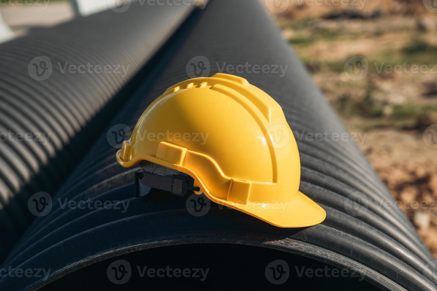 A hard hat sitting on top of a pipe photo