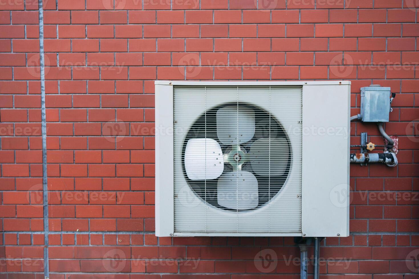 A wall mounted air conditioner on a brick wall photo