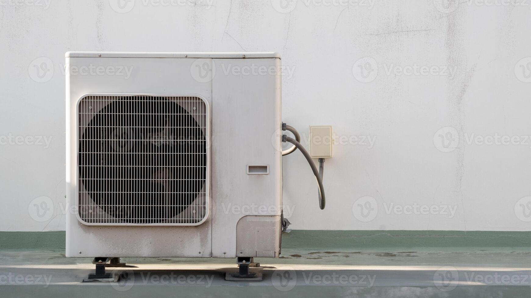 A white air conditioner sitting on a concrete floor photo