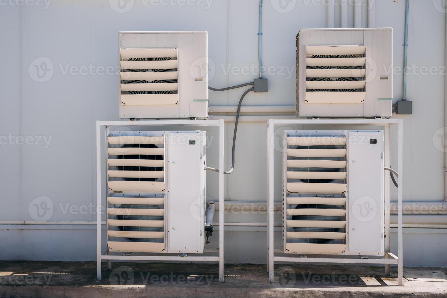 Two air conditioners on a wall outside photo
