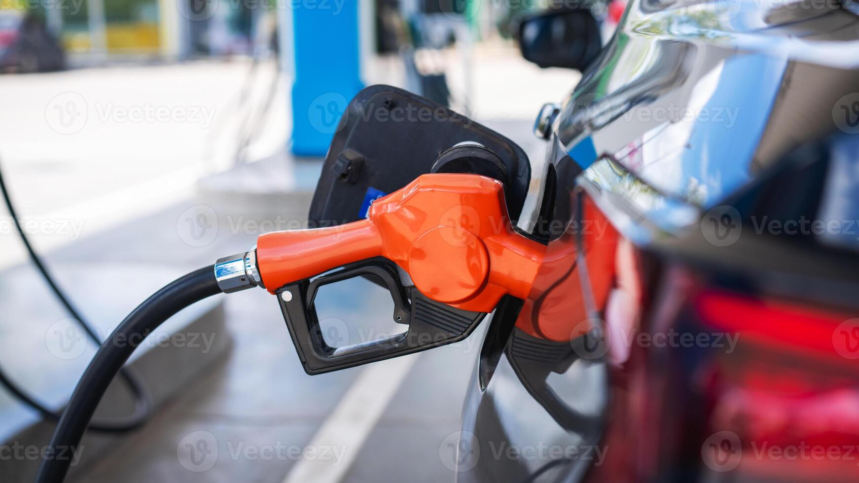 A gas pump is attached to a car photo