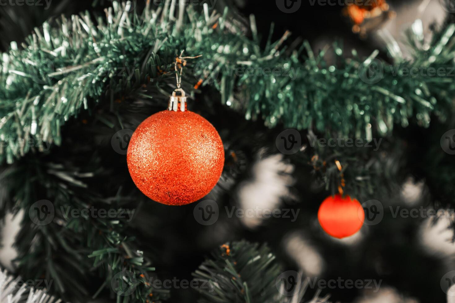 A christmas tree with two red balls hanging from it photo