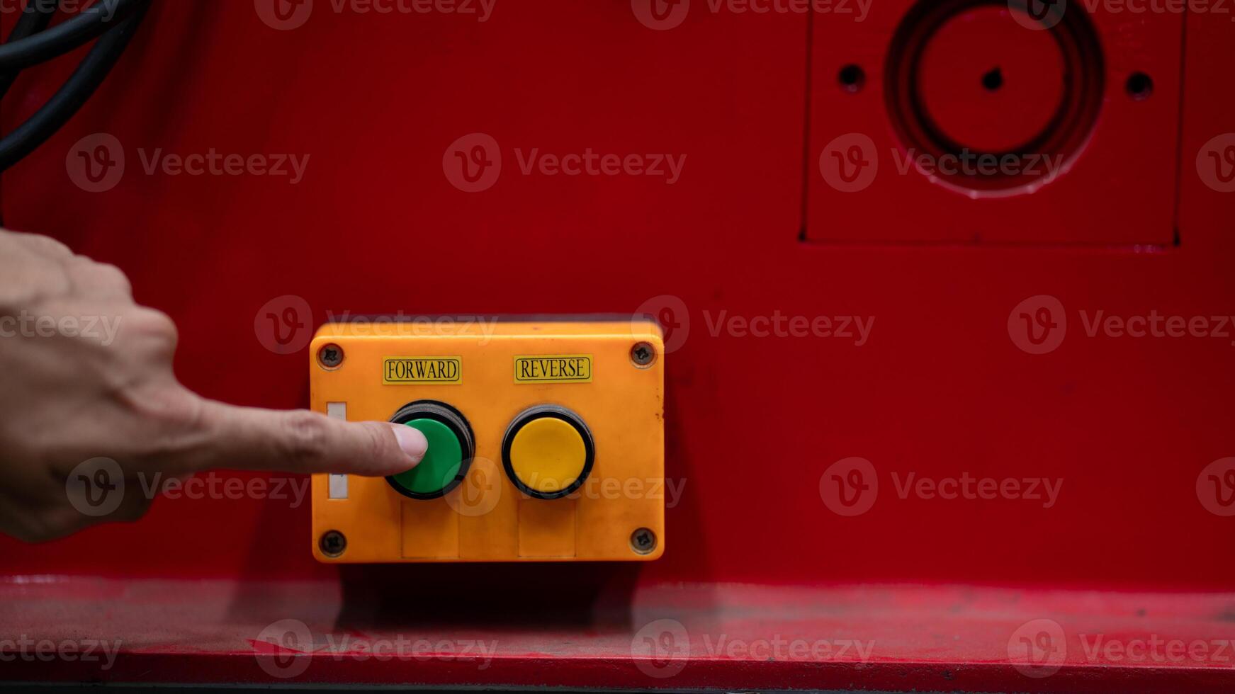 A person pressing a button on a red machine photo