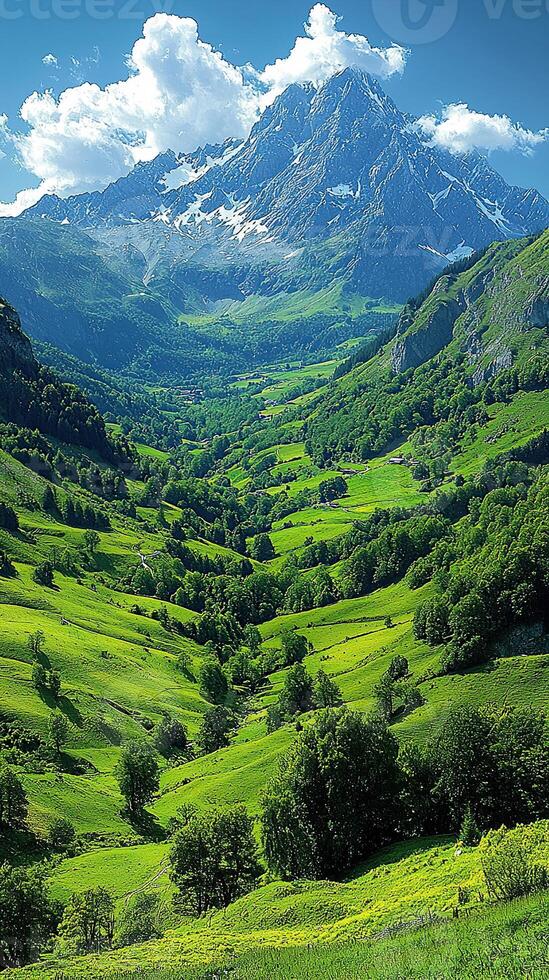 A breathtaking mountain valley view, with lush greenery leading to snow-capped peaks. photo