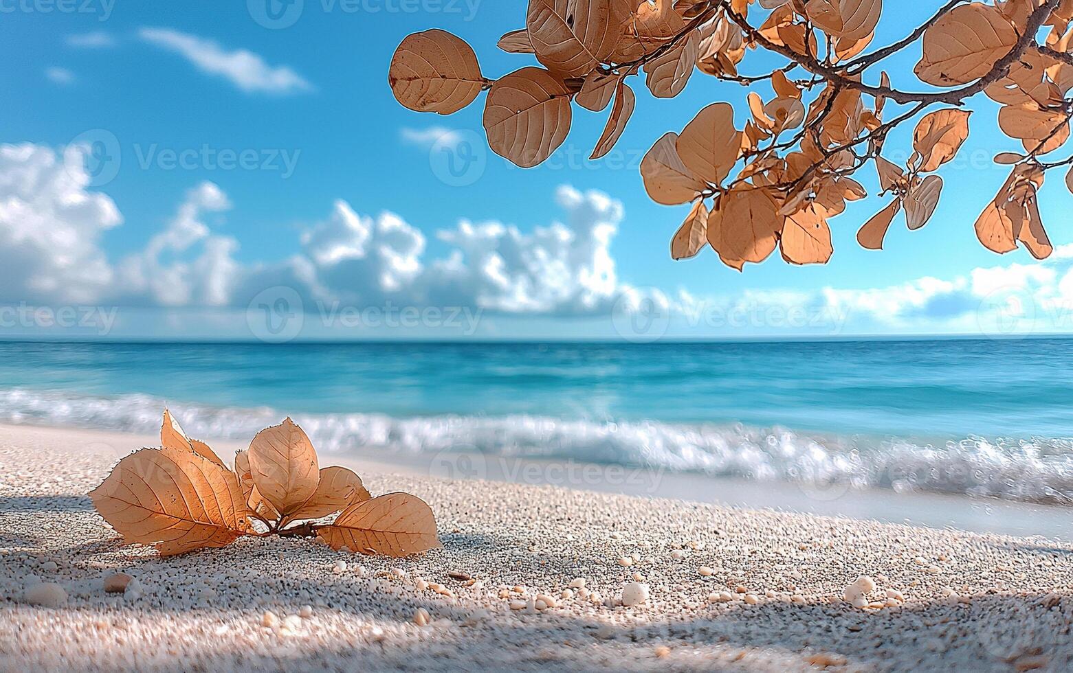 Golden leaves grace a sandy beach with azure ocean and sky creating a serene coastal vista. photo
