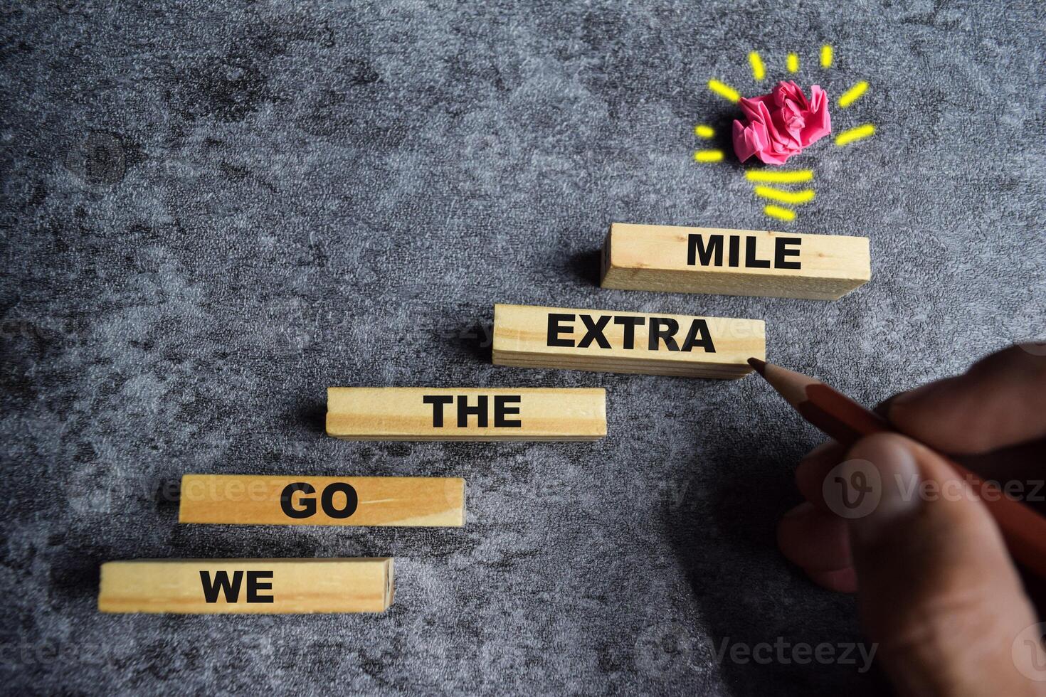 Concept of We go the extra mile Symbol. Wooden blocks stacking as step stair We go the extra mile photo
