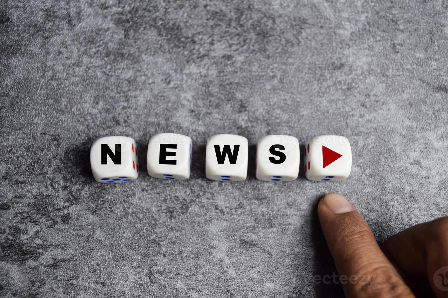 male hand presses the play button with news on dice or wooden cubes photo