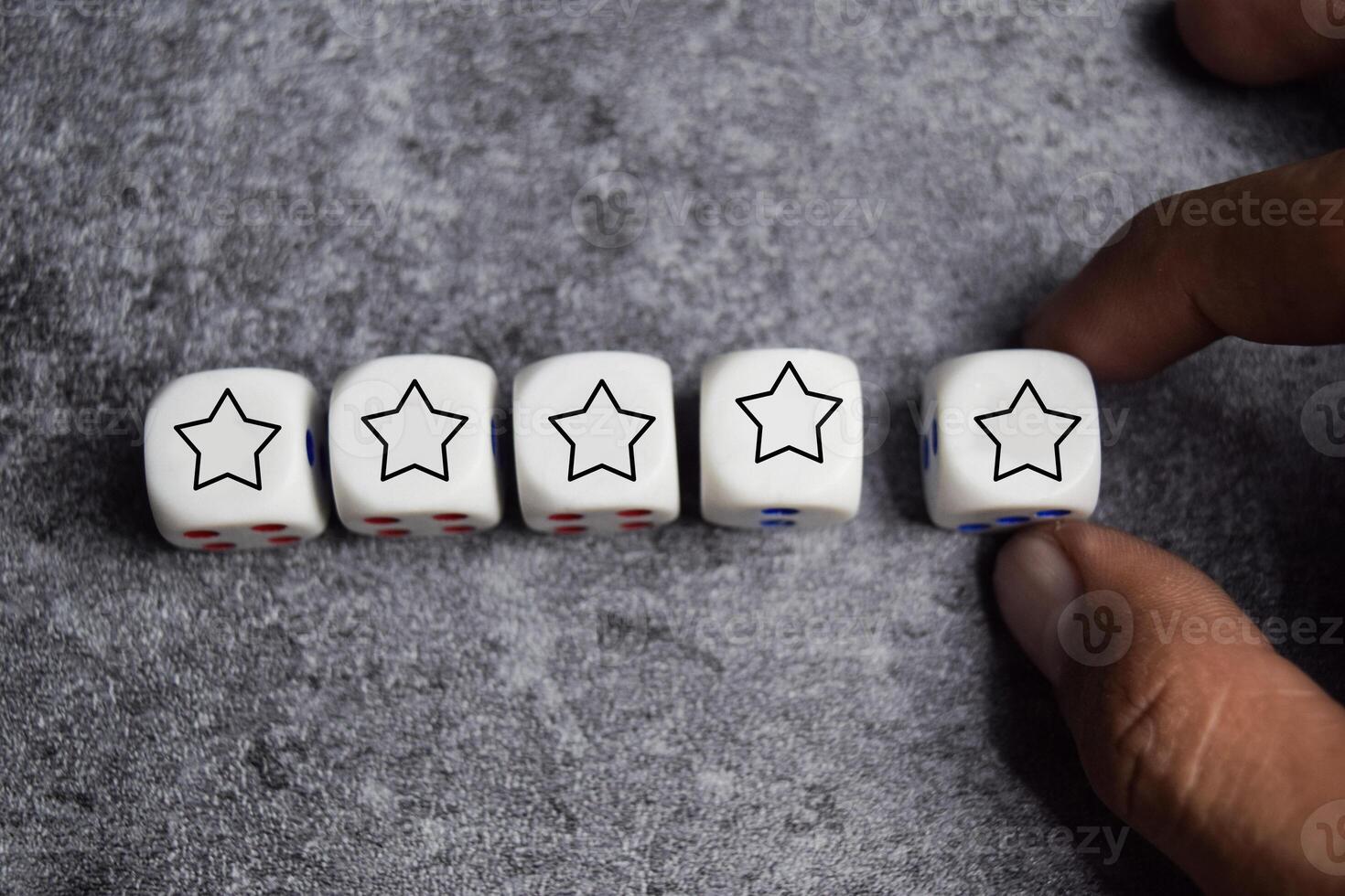 male hand placing wooden cubes or dice with five star on the table. Customer experience or satisfaction survey concept photo