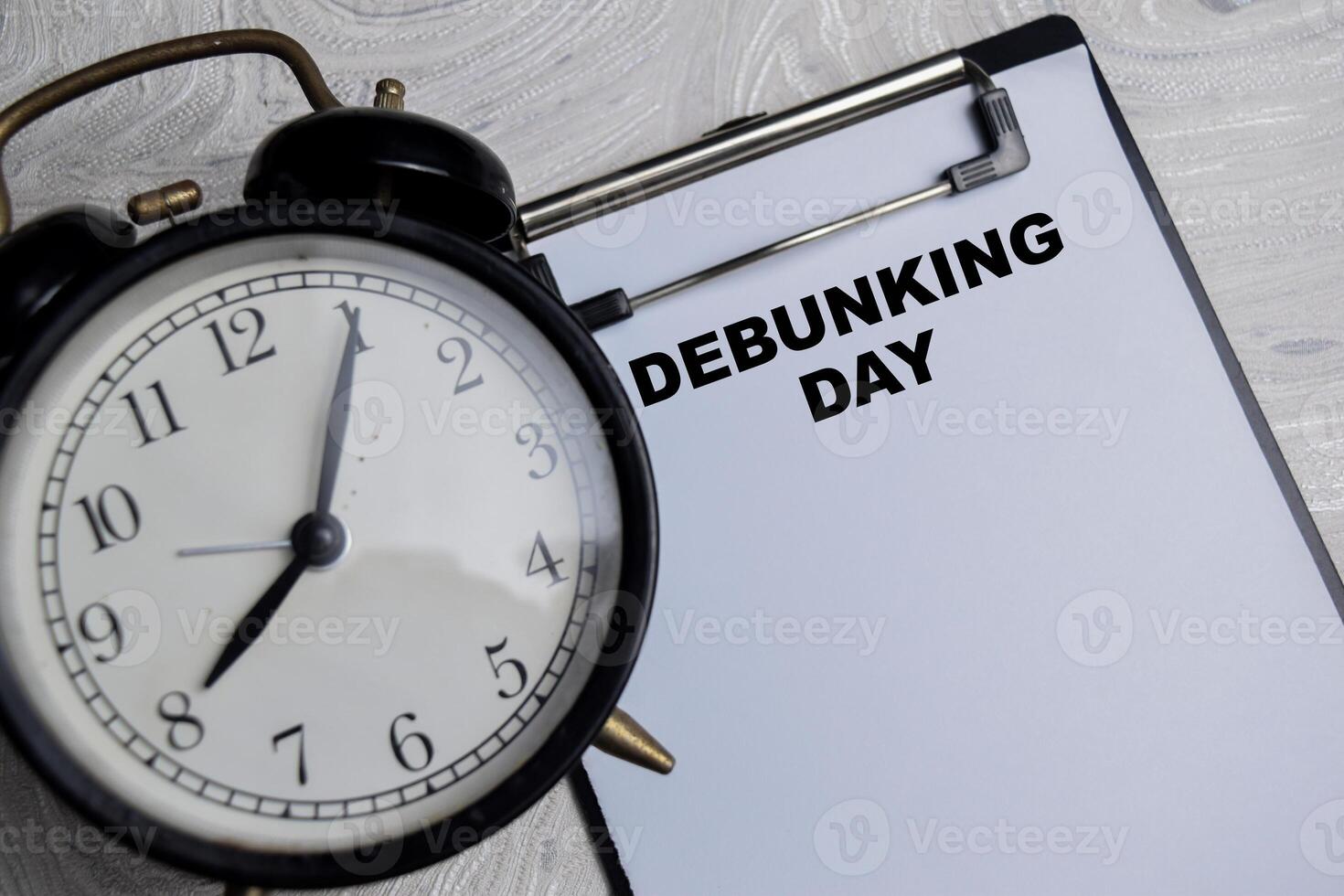 Concept of Debunking Day write on paperwork isolated on Wooden Table. photo