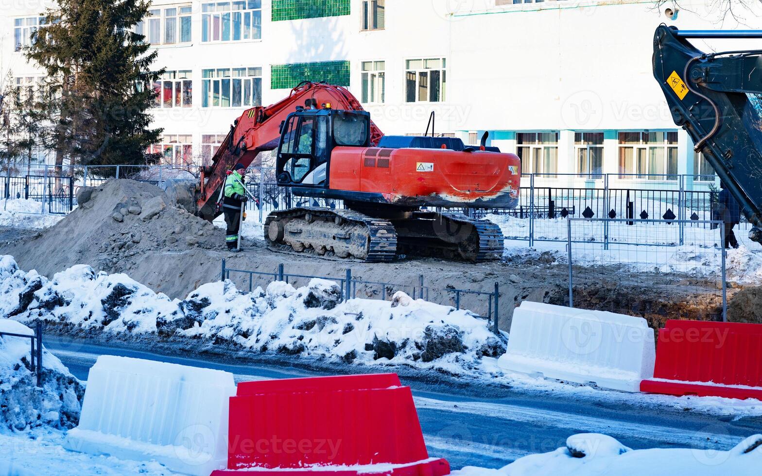 Excavator during earthmoving on blue sky background. Construction machinery and earth-moving heavy equipment for excavation, loading, lifting and hauling of cargo on job sites photo
