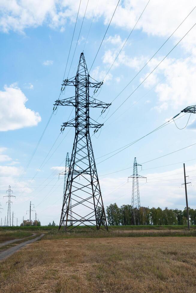 High voltage lines in a flat and green agricultural landscape on a sunny day with cirrus clouds in the blue sky. photo