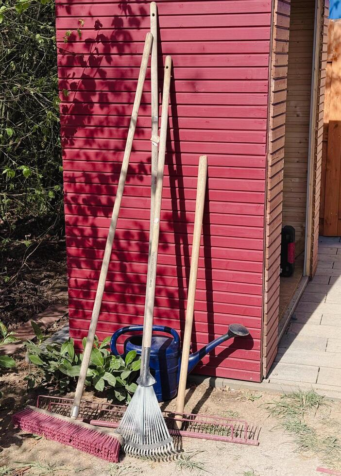 A variety of garden tools positioned on artificial grass for outdoor gardening. Several garden tools, including a rake, shovel, and pruners, are arranged . photo