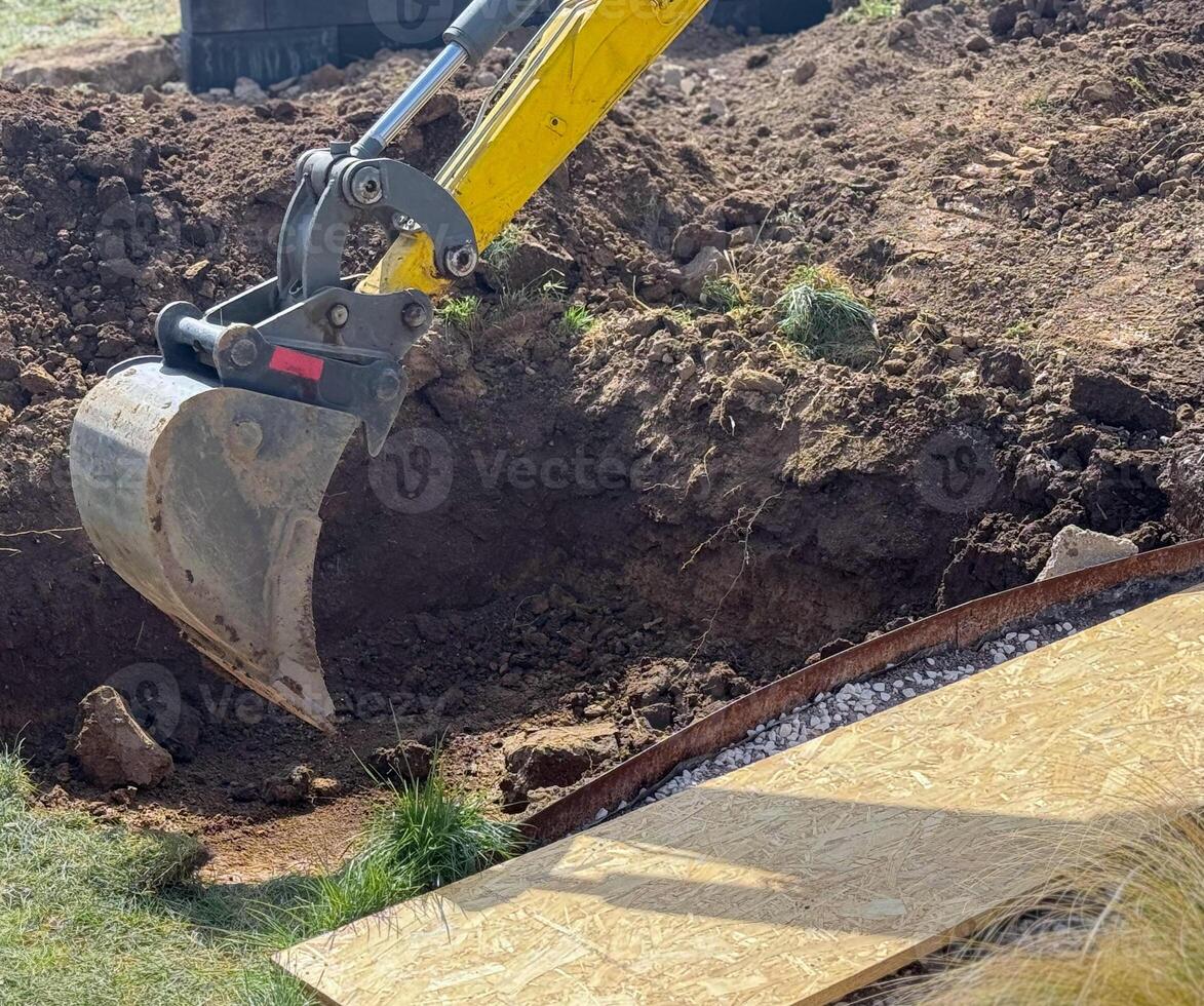 Close up view of excavator bucket digging ground on construction site photo