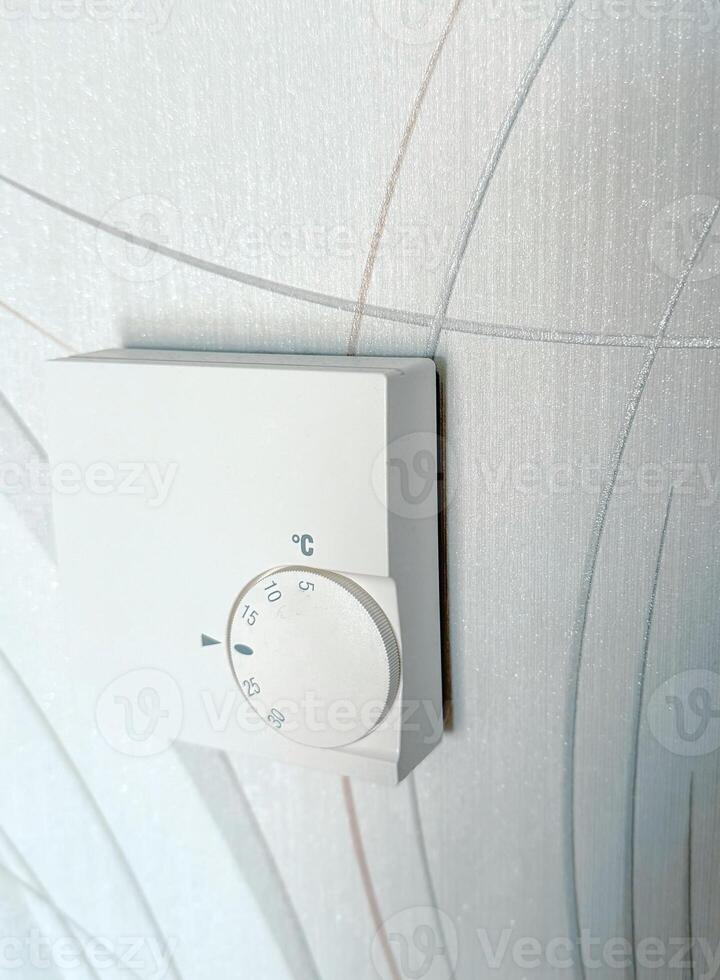 Modern thermostat for setting and maintaining the temperature in the house. Heating by the system of warm floors photo