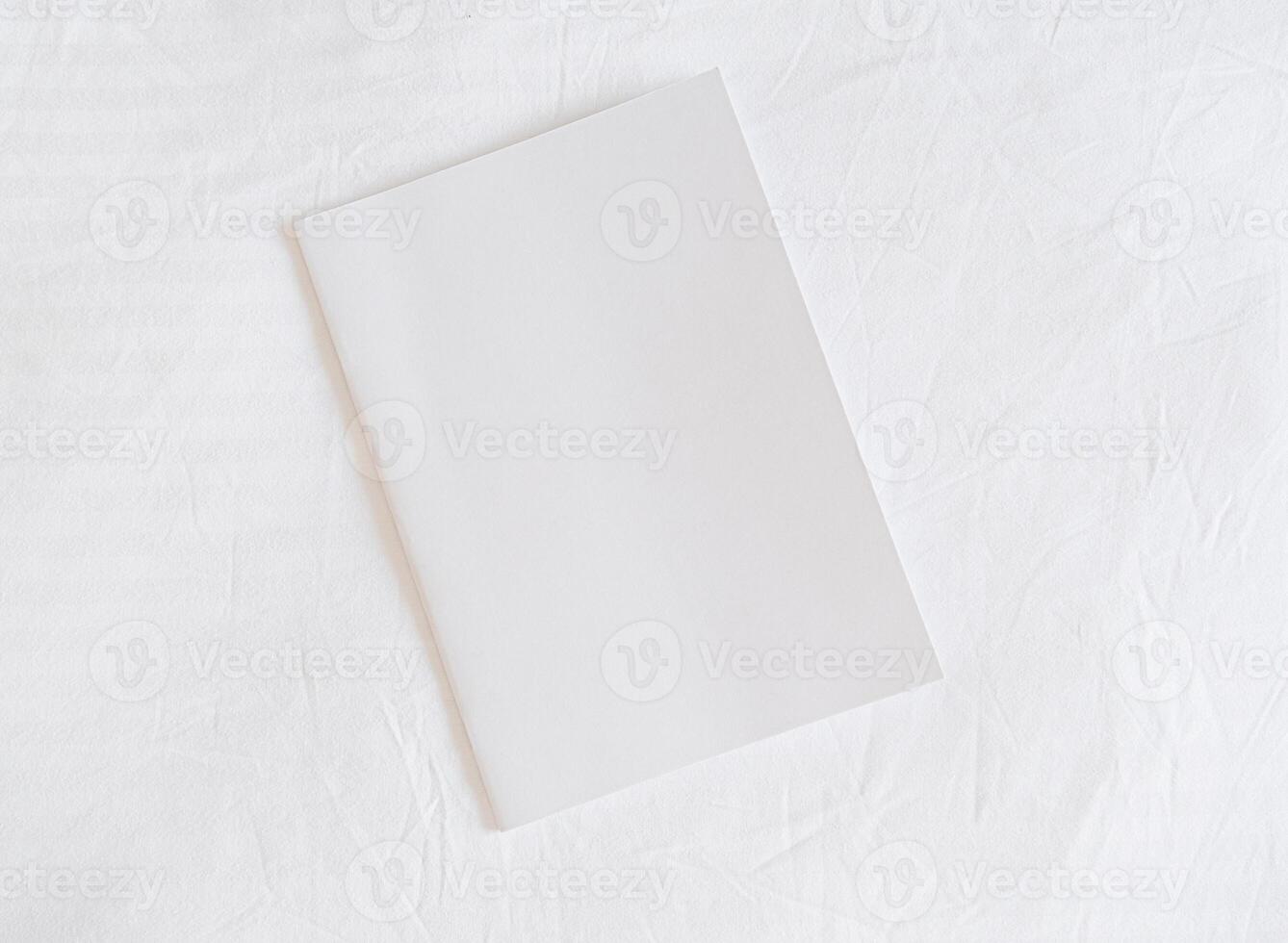 White magazine mockup on white bed , mockup design photo