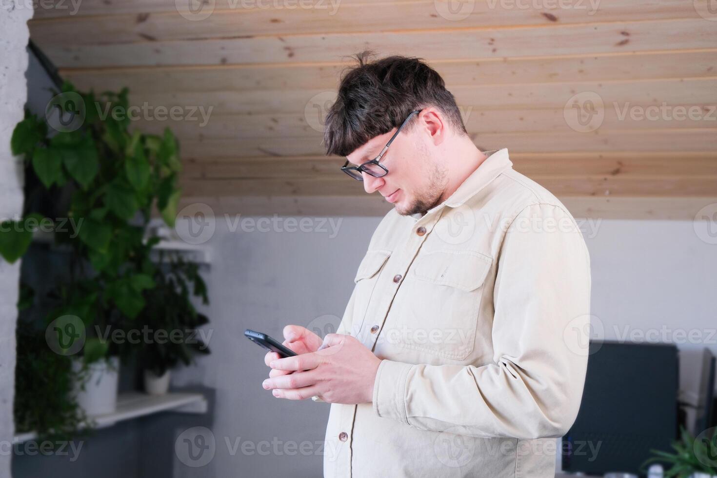 caucasian young man using smart phone cellphone for calls, social media, mobile application photo