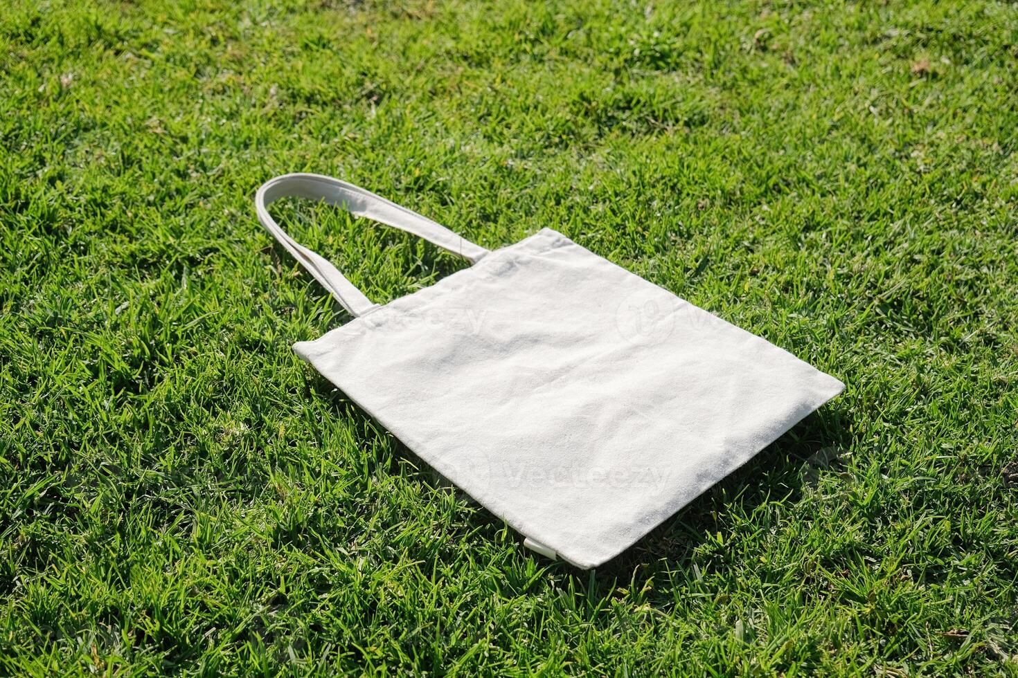Canvas tote bag on green grass outdoor photo