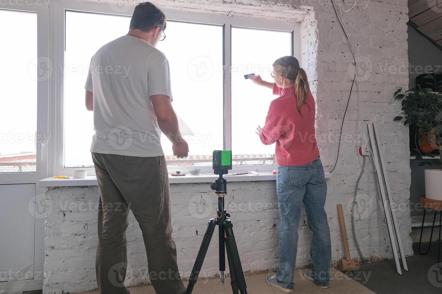 millennial couple toning windows glass at home using toning film photo