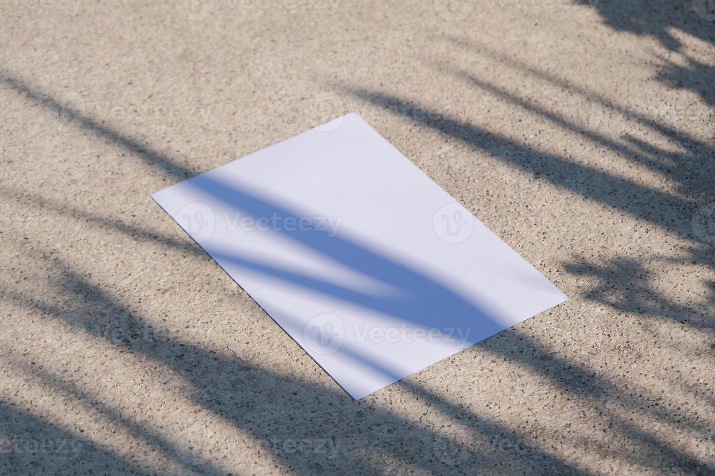 empty paper poster mockup on concrete stone floor or pavement outdoors, leaves shadow overlay photo